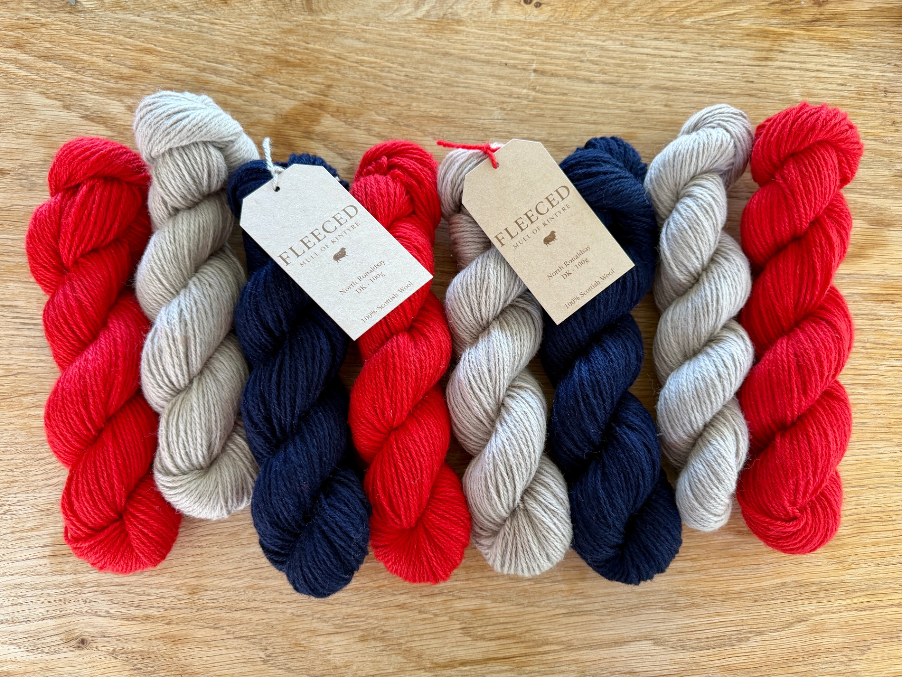 Skeins of natural Fleeced yarn on an oak table